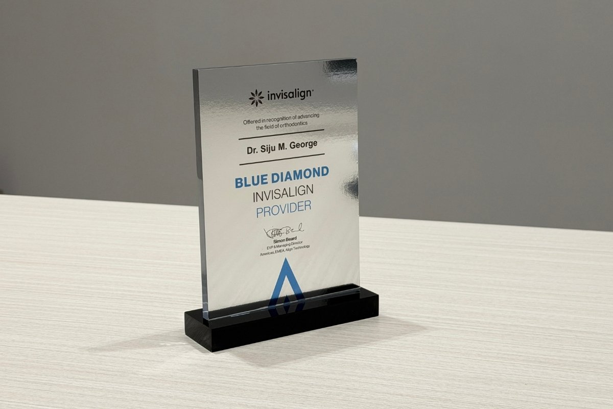 Dr. Siju George with the Invisalign Blue Diamond award — top 1% Invisalign provider recognition