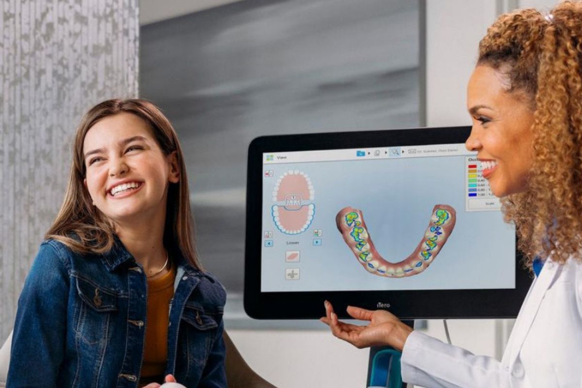 Patient and clinician viewing a 3D digital scan of teeth on screen during an Invisalign consultation — iTero digital scanning technology