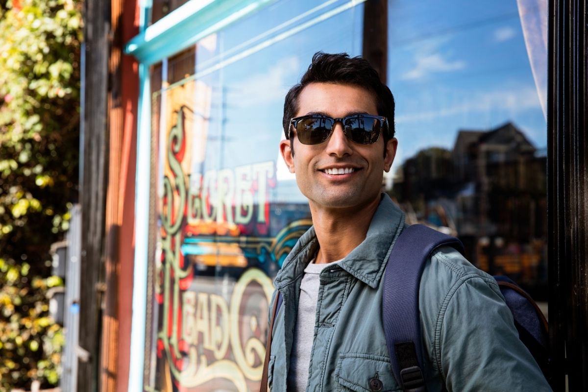 Young man with a confident smile outdoors after orthodontic treatment — straight teeth and lifestyle confidence